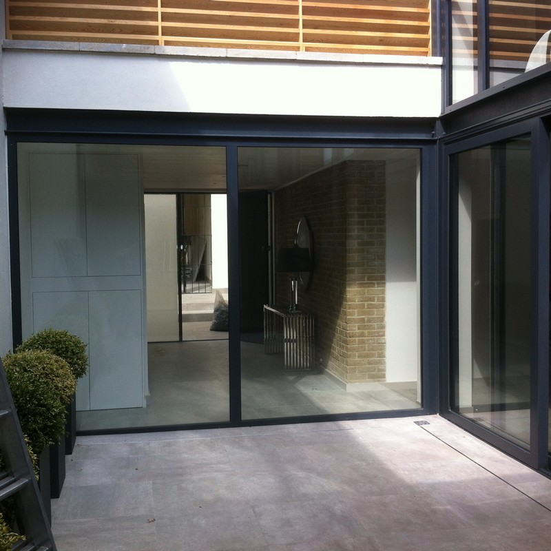 Floor-to-ceiling sliding doors opening to courtyard in Bushey